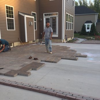 Master Landscaping Sprinklers - a man standing in front of a house - Landscaping Near Me