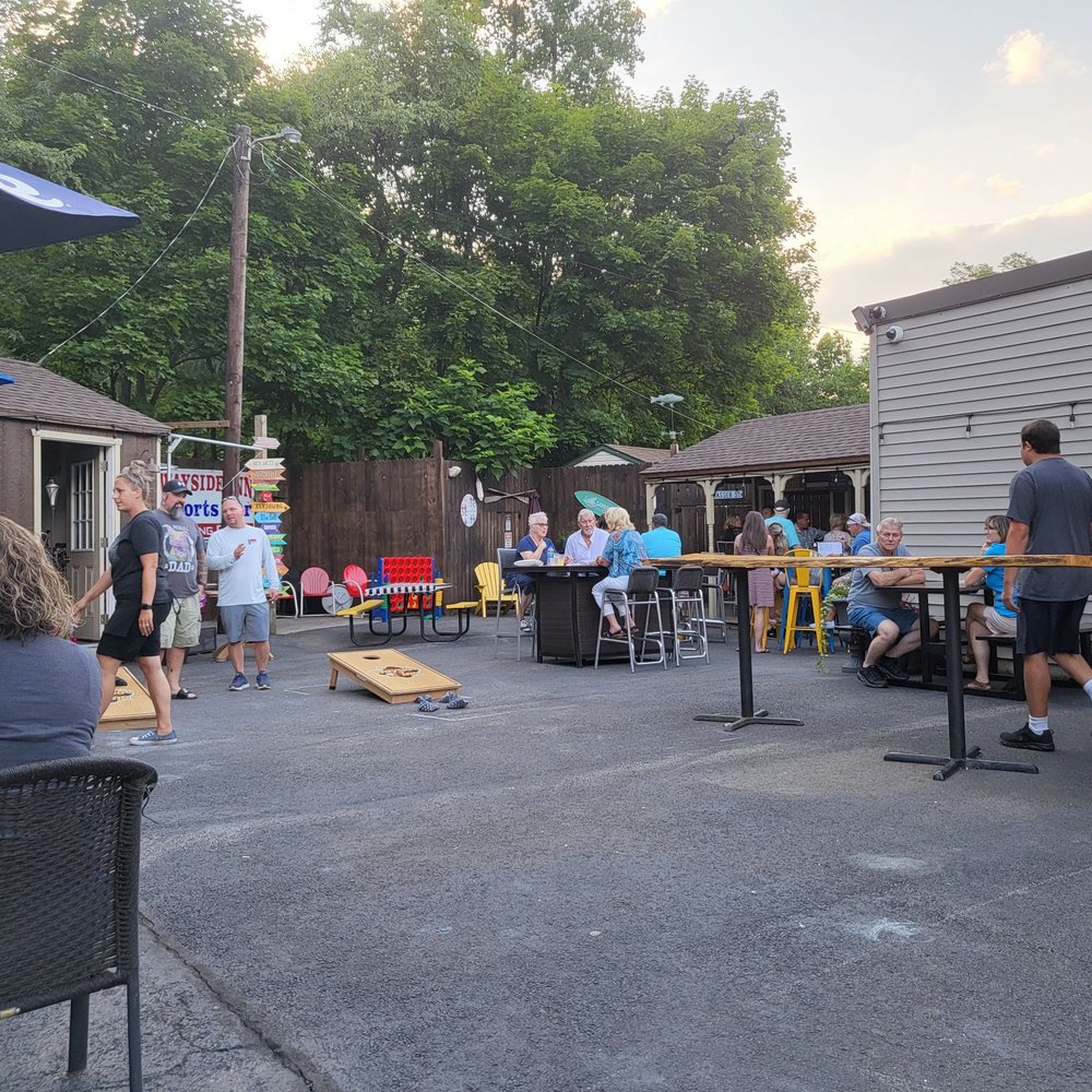 a group of people sitting at tables outside a group of people sitting at tables outside