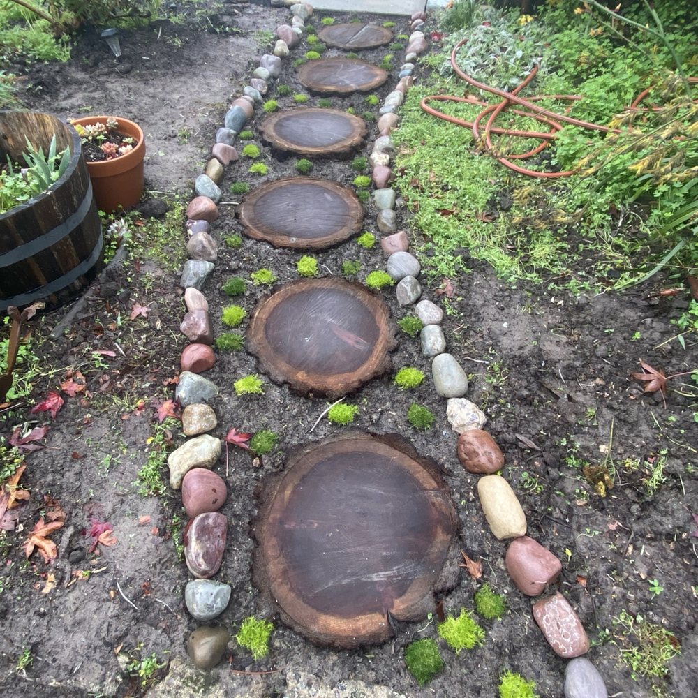 Leveled redwood path with newly planted moss and river rock edge
