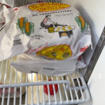 Mike's Quick Mart - Milagro Tortillas - A bag of El Milagro tortillas is placed on a freezer shelf in a store, with a large container of milk below. - Convenience Stores Near Me - Manassas, Virginia