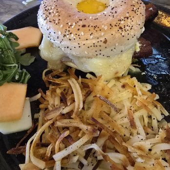 Buck & Honey's - The Cure with hashbrowns - A breakfast plate includes a bagel with egg and cheese, accompanied by crispy hashbrowns and slices of cantaloupe melon. - American Near Me - Monona, Wisconsin