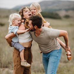 Paige Rance Photography - a family of four laugh while running and playing tag in a field at a family photography session in McKinney