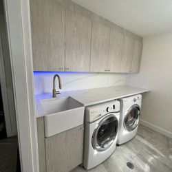 Ritz Renovation - high-end laundry room with farmhouse sink and quartz countertop and backsplash, with LED undermount lights