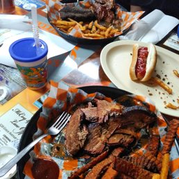 a plate of ribs, fries, and a hot dog a plate of ribs, fries, and a hot dog