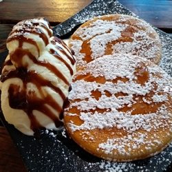 House Of Pumpkin - Pancakes topped with maple syrup and icing sugar accompanied by ice-cream topped with chocolate sauce.