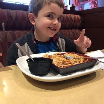 Boston Pizza - a young boy sitting at a table with a plate of spaghetti - Chicken Wings Near Me - Winnipeg, Manitoba Boston Pizza - a young boy sitting at a table with a plate of spaghetti - Chicken Wings Near Me - Winnipeg, Manitoba