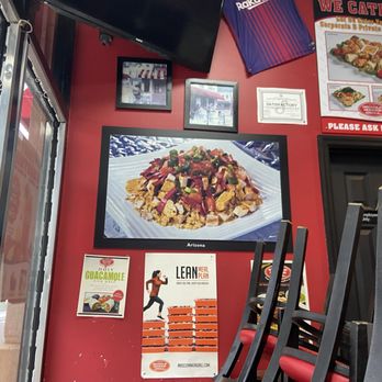 Muscle Maker Grill - a red wall with posters on it - American Near Me - Lodi, New Jersey