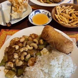 Shrimp with cashews, the other plate is chicken and cashews, there's also crab raccoons and the sesame sticks with duck sauce