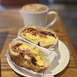 Bacon egg and cheese breakfast bagel with a latte. Bacon egg and cheese breakfast bagel with a latte.