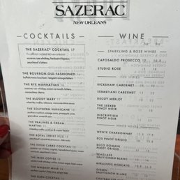 Menu - The menu from Bar Sazerac in New Orleans features a list of cocktails and wines, with descriptions and prices. It includes drinks such as the Sazerac Cocktail, Bourbon Old Fashioned, Rye Manhattan, and various wines like Capolado Prosecco and Studio Rose. The menu is printed on white paper with black text, organized into sections for cocktails and wines, and provides details about each beverage's ingredients and pricing.