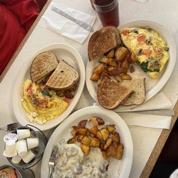 a plate of eggs, toast, hash browns, and a cup of coffee