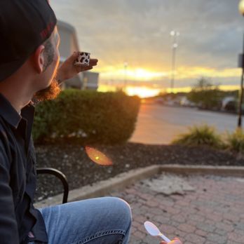 Udderly Moolicious - a man sitting on a bench eating a donut - Ice Cream & Frozen Yogurt Near Me - Warrenton, Missouri Udderly Moolicious - a man sitting on a bench eating a donut - Ice Cream & Frozen Yogurt Near Me - Warrenton, Missouri
