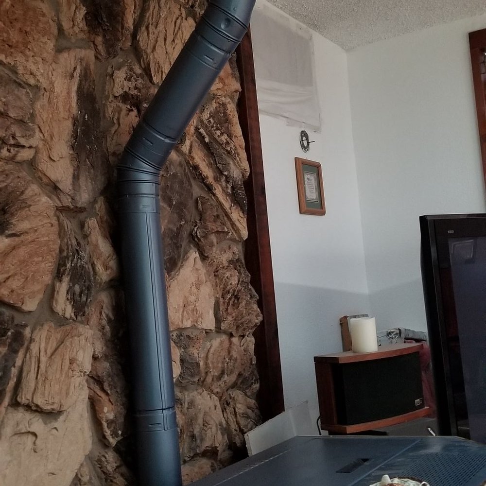 Zoe Landscaping - Faux brown rock behind pellet stove; vents up through chimney access. - Landscape Architects or Designers Near Me