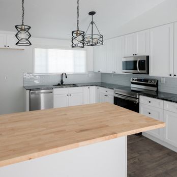 Atlas Renovations - a kitchen with white cabinets and stainless steel appliances - Flooring Near Me Atlas Renovations - a kitchen with white cabinets and stainless steel appliances - Flooring Near Me