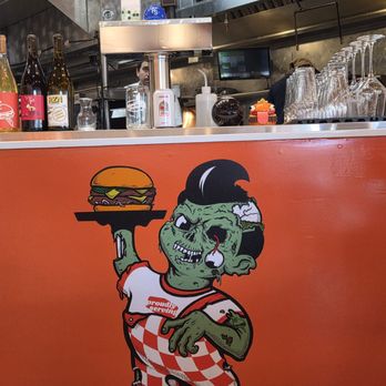 Proudly Serving - Inside counter with burger boy logo - Burgers Near Me - Redondo Beach, California