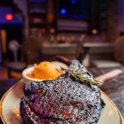 Tomahawk Steak: Masterfully smoked to capture deep bold flavors, then charbroiled over an open flame for a lightly charred crust.
