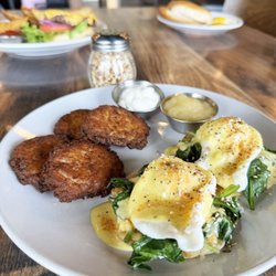 Florentine Eggs Benedict. English muffin topped with poached eggs, sauteed spinach and homemade hollandaise sauce.