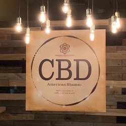 CBD American Shaman - Our company logo set against our counter pallet board wall with a glow of our Edison lights