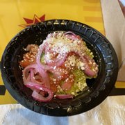 Photo of Tequileria - Charlotte, NC, United States. Guacamole from a bag with some pickled onions and tomatoes.
