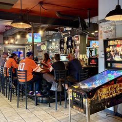 Backstreet Tavern & Grill - Looking over the bar area. There is a pinball machine. High chairs for small kids are available as well!!