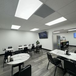 The eating area inside the restaurante features two four person tables and three two person tables.