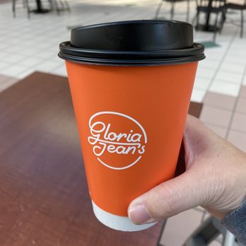 Gloria Jeans Coffees - a hand holding a cup of coffee - Coffee & Tea Near Me - Rochester, New York