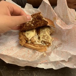 a person taking a bite out of a sandwich