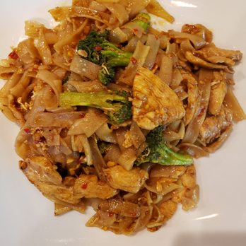 Paste Thai - Pad Si Ew with chicken - A plate of Pad Si Ew with chicken, featuring wide rice noodles, broccoli, and chicken pieces, served on a white dish. - Thai Near Me - Davis, California