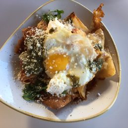 Chilaquiles: Tortilla Chips, Salsa, Cilantro, Chihuahua Cheese, Refried Black Beans, Red Onions, Sour Cream, Sunny Side Up Egg