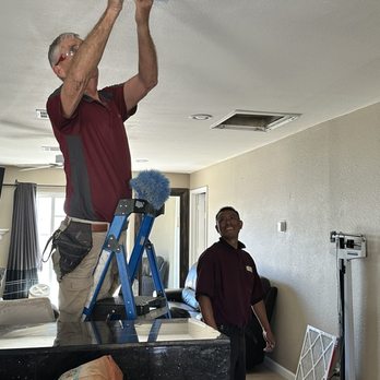 Duct Pros - Jackson placing the vent cover back on and Mario getting ready to clean out the register. - Air Duct Cleaning Near Me