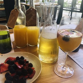 Sixty Vines - Mimosa bar with pineapple and mango juice and mixed fruit. - New American Near Me - Dallas, Texas