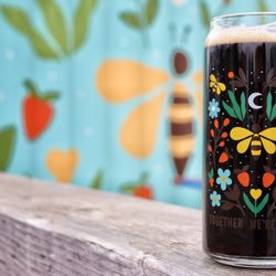 Together We're Bitter Cooperative Brewing - Stout in a limited edition Morningstar Designs glass in front of the Morningstar mural on the TWB patio.