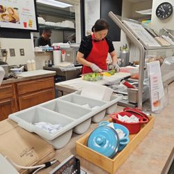 Elite Cafe - Helen preparing salad, fresh cutting veggies with care.