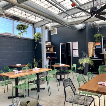Bon Bon - a restaurant with tables and green chairs - Thai Near Me - Lawrence, Kansas
