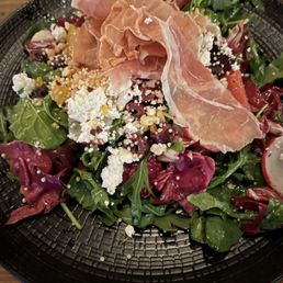 Salad topped with serrano ham