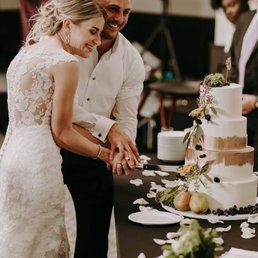 a bride and groom cutting their wedding cake