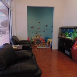 Xpress Dental - Relaxing waiting area with individual couches, visually appealing aquarium, and reading materials