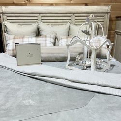 Moss Creek Home Interiors - Forty West Aubrey Chandelier, Eastern Accents Aldrich Bedding, Suede Hides by Moore and Gilesju, and the Belmont Bed by Napa Furniture.