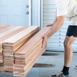 Wallcraft Reclaimed Wood - Clean redwood planks stacked by woodworker
