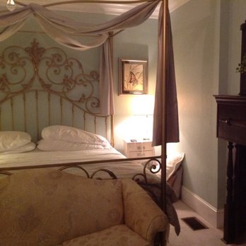 White Doe Inn - Bed and side table - Bed & Breakfast Near Me - Manteo, North Carolina