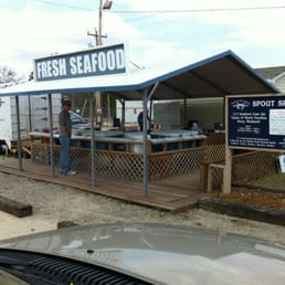 a man standing in front of a seafood stand a man standing in front of a seafood stand