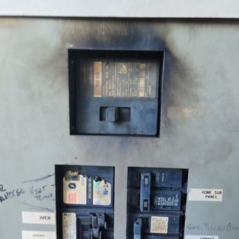 High End Electric - Before: Severely outdated and unsafe electrical panel with an old analog meter, exposed components, and worn breakers -- a fire hazard - Electricians Near Me High End Electric - Before: Severely outdated and unsafe electrical panel with an old analog meter, exposed components, and worn breakers -- a fire hazard - Electricians Near Me