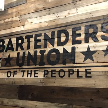 Bartenders Union - a woman standing in front of a sign - Sports Bars Near Me - Gilroy, California