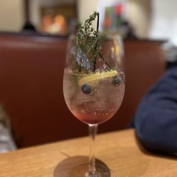 a glass of wine with a sprig of rosemary