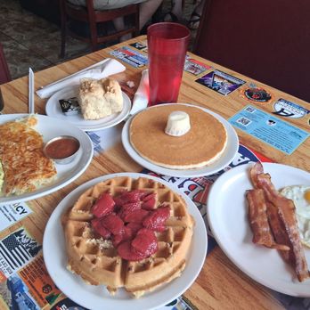 Dinner Bell Cafe - Our spread. Waffle with pecans and strawberries with eggs & bacon, his Southwest omelet with hash browns & biscuit. - Breakfast & Brunch Near Me - Prescott, Arizona