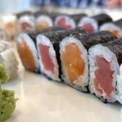 Fuji Sushi & Steakhouse - Tuna rolls and salmon rolls accompanied by a large chunk of wasabi.
