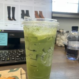 a cup of green tea next to a croissant a cup of green tea next to a croissant