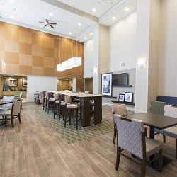 Hampton Inn & Suites Hartford-Manchester - Our hotel lobby provides a welcoming atmosphere with floor to ceiling windows, comfortable furniture, and space to enjoy a meal.