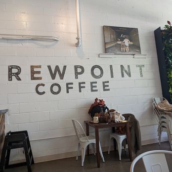 Brewpoint Craft Elmhurst - The image shows the interior of Brewpoint Coffee, featuring a white brick wall with the business name and a green plant wall on the right. - Coffee & Tea Near Me - Elmhurst, Illinois