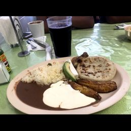 This is a breakfast dish that comes with pupusas fried plantains, beans, rice, and Salvadoran cream.